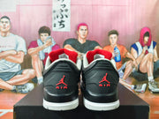 Rear view showing red heel logos and white midsoles on the black sneakers.