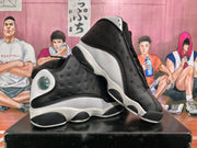 Angled view of a pair of black and white high-top sneakers highlighting perforated side panels and contrasting midsoles.