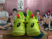 Front view of lemon-yellow ASICS basketball shoes with black side branding and orange-red tongue accents.