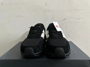 Front view of black New Balance U370 sneakers with black laces and light-colored side panels.