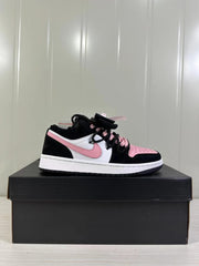 Side profile of one black, white, and pink low-top sneaker on a black shoebox.