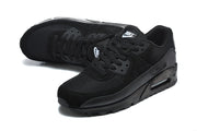 Pair of black Nike Air Max 90 sneakers in a front three-quarter view.