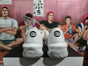 Rear view of white basketball sneakers showing matching circular GT heel marks and textured outsoles.
