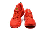 Front view of the red sneakers showing tonal laces, padded tongues, and logo patches.
