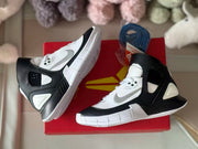 Side view of the black-and-white high-top sneakers showing the layered upper and white outsole.