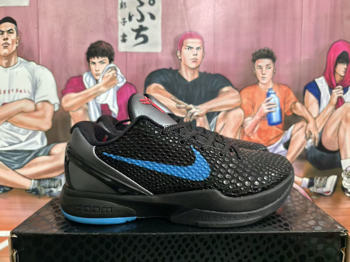 Side view of black Nike Kobe basketball sneakers with a textured upper, blue swoosh accent, and blue outsole detail on a patterned box.
