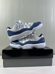 Pair of white and blue Jordan Air Jordan 11 Low sneakers stacked together