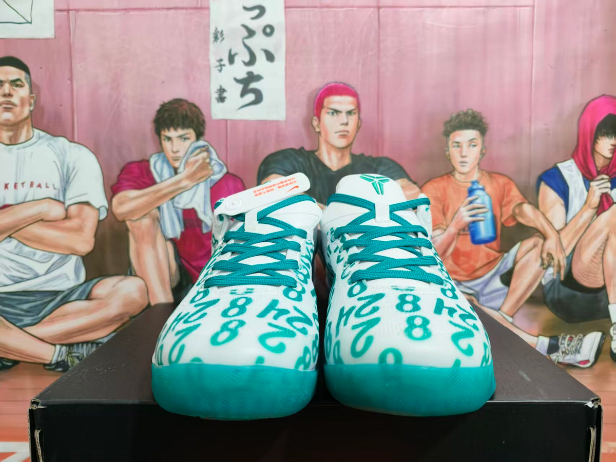 Front view of white Nike basketball sneakers with teal-green graffiti lettering, teal laces and teal outsoles.