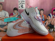 Angled view of white Nike basketball shoes showing pink side panels and speckled outsoles
