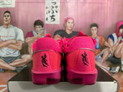 Rear view of bright pink Nike basketball shoes with black heel branding, displayed on a shoebox.