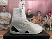 Side view of a white high-top basketball sneaker with a textured upper, raised collar, and black midsole detail.