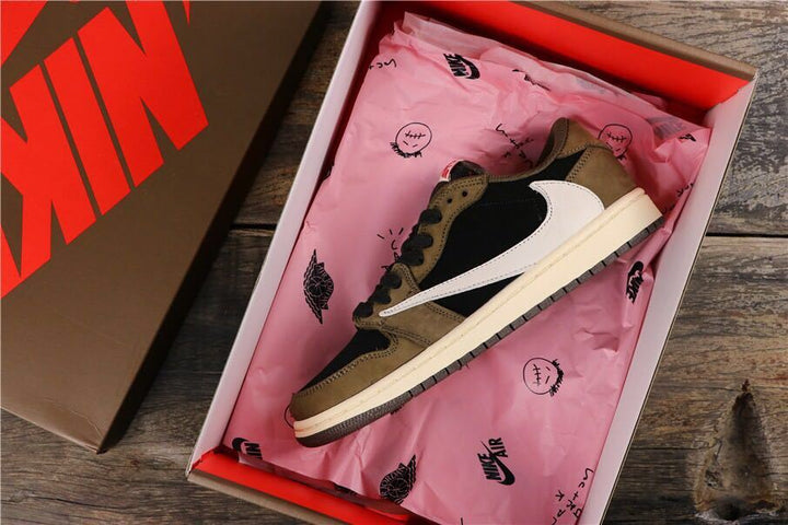 Brown and black low-top sneaker displayed in a shoe box with pink tissue paper.