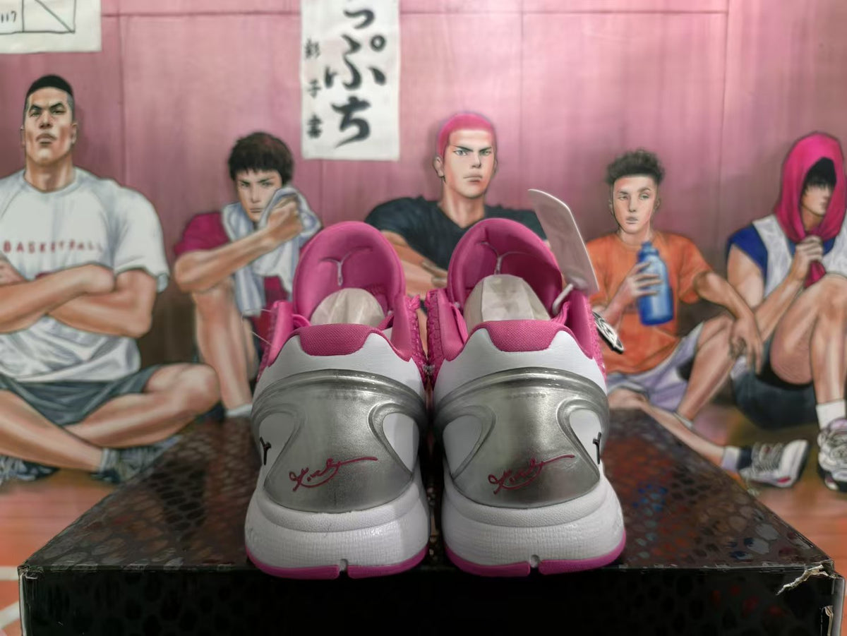 Rear view of pink and white Nike basketball sneakers showing silver-gray heel panels and pink outsole accents.