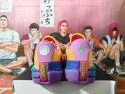 Rear view of the sneakers showing purple heel panels, contrasting blue and pink structures, green lettering, and purple tread.
