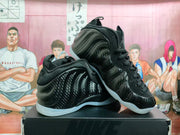 Pair of black high-top sneakers shown from the side with glossy patterned uppers
