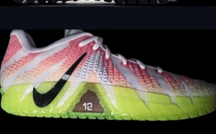 Side view of white Nike 928 sneakers with pink textured panels, bright green lower sections, and a black Swoosh.