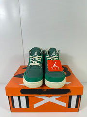 Front view of the pair showing cream laces, green uppers, and Jumpman tongue logos.