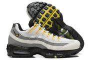 Side and outsole views of white, grey, black, and yellow Nike Air Max 95 TT sneakers.