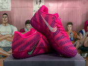 Angled view of pink Nike basketball sneakers showing the side Swoosh, patterned upper, laces, and translucent sole.