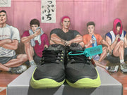 Front view of black Nike Kobe basketball shoes with volt-green soles and speckled tongue details