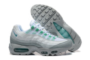 Side and outsole views of white, grey, and green Nike Air Max 95 TT sneakers