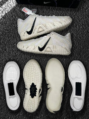 Side views of the sneakers highlighting the black Swoosh, textured off-white upper, and patterned outsole.