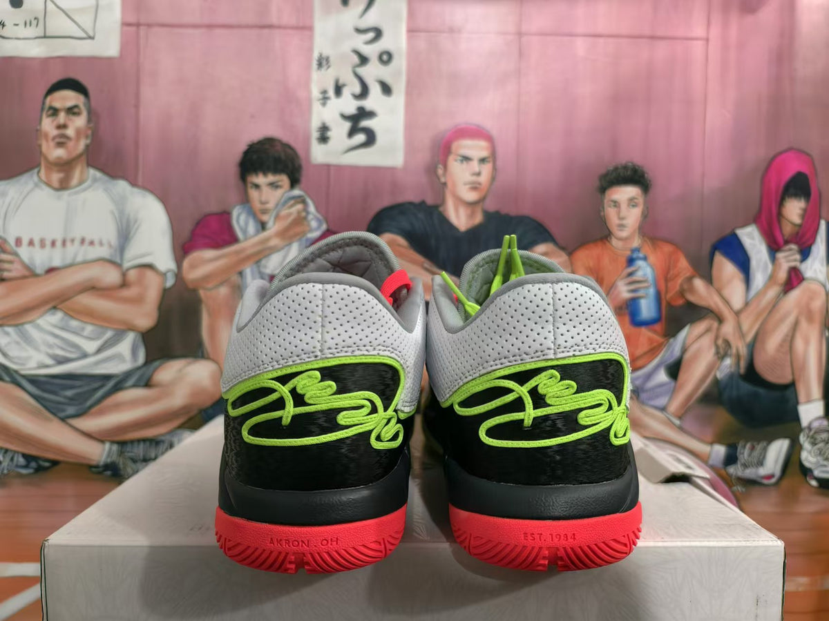 Rear view of white, black, green, and coral-red Nike basketball shoes