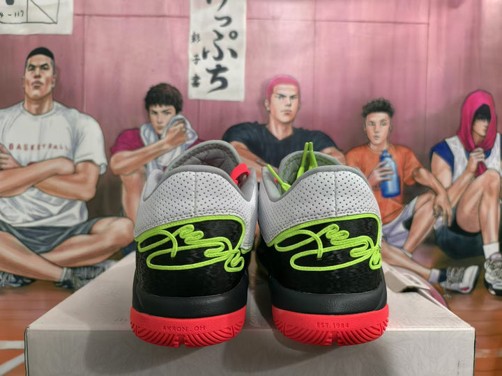 Rear view of white, black, green, and coral-red Nike basketball shoes