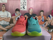 Front view of coral and turquoise basketball sneakers showing perforated toe areas, matching laces, speckled midsoles and translucent-looking green outsoles.