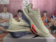 Angled view of beige Nike sneakers displaying the lace-up upper, black side branding, red accents, and ZoomX midsole text.