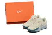 Cream Nike G.T. Cut Academy basketball shoes beside an orange Nike shoebox.