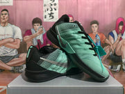 Pair of mint green and black Nike basketball sneakers with silver Swooshes, shown from an angled side view.