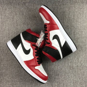 Angled side view of the pair showing the black Swoosh, red overlays, white side panels, and layered sole construction.