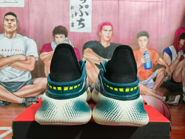 Rear view of teal and white basketball shoes with yellow heel accents displayed on a shoebox.