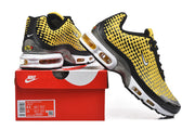 Yellow, black, and silver Nike Air Max Plus sneakers displayed with a Nike shoebox.