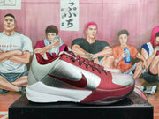 Side view of burgundy and silver Nike basketball sneakers with a white midsole and side Swoosh.