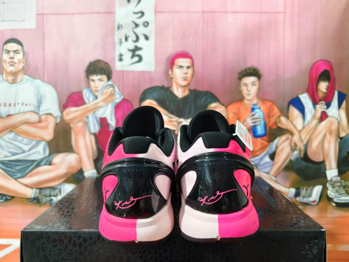 Rear view of pink-and-black mismatched Nike basketball shoes displayed on a box.