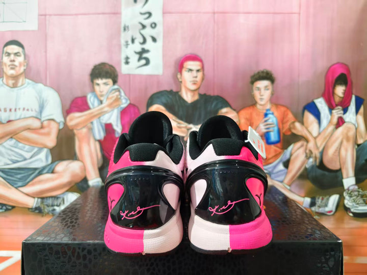 Rear view of pink-and-black mismatched Nike basketball shoes displayed on a box.