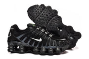 Black Nike Shox TL sneakers shown from the side and underside, highlighting the patterned outsole.
