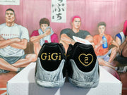 Rear view showing black heel collars, gold GiGi lettering and heart emblem details, and marbled gray midsoles.