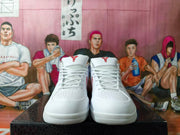 Front view of the white basketball shoes showing laces, perforated toe panels, and red tongue logos.