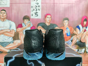 Rear view of black basketball sneakers with blue translucent outsoles on a shoebox.