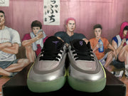 Front view of the pair showing black laces, silver toe boxes, dark collars, and green outsole edges.