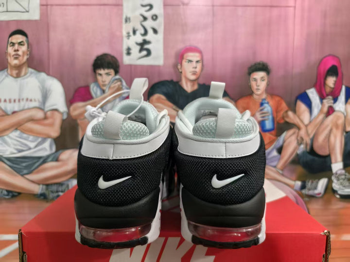Rear view of white and black Nike sneakers showing heel branding and red-tinted sole cushioning.