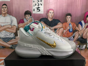 Side profile of a white Nike basketball sneaker with a gold swoosh, textured upper, sculpted midsole, and patterned toe panel.