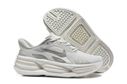 Light grey Nike sneakers shown from the side and outsole, with patterned tread visible.