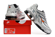 Nike Shox Ride 2 sneakers in grey, white, black and orange shown with a shoebox; box label displays size markings for the photographed pair.
