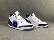 Front three-quarter view of the pair showing the white and purple colorway and patterned toe overlays.