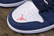 Close-up of the perforated white toe box with a red Jordan emblem and navy trim.