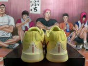 Rear view of yellow Nike sneakers showing padded collars, heel panels, and contrasting red details.